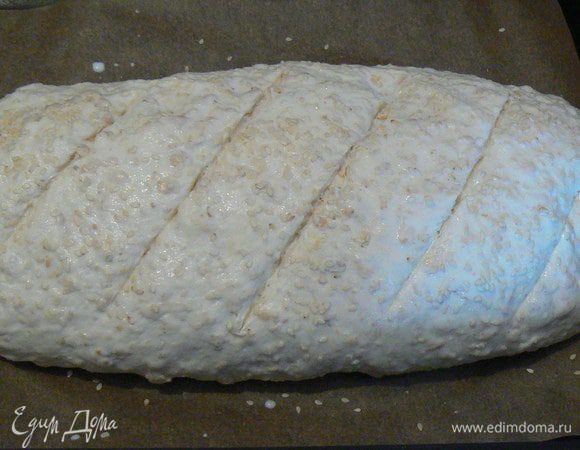 Обмять, сформировать буханку, выложить на противень и оставить в тепле еще на 30 минут. Духовку разогреть до 200 градусов. Сделать на буханке надрезы, смазать сверху молоком и посыпать кунжутом. Выпекать 30 минут.