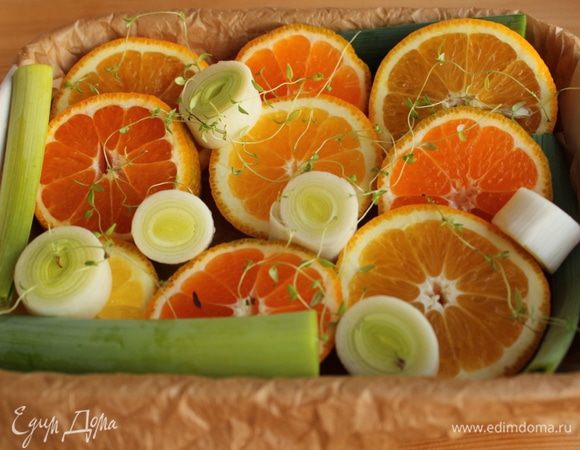 Апельсин, мандарины и порей нарезать толстыми колечками и выложить в форму, застеленную пергаментом. 