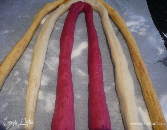 Плетем нашу косу. Разделяем каждый оставшийся колобок на две части, оставив от каждого совсем небольшой кусочек для закрывания пирога (примерно по 4 см в диаметре) и делаем из каждой части жгут длиной 45 см. Укладываем наши жгуты на пекарскую бумагу. У нас получится 6 жгутов.