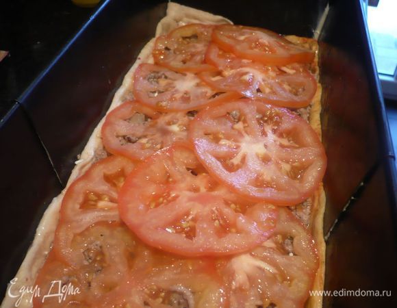 Выкладываем на наше тесто. Сверху выкладываем ломтики помидоров, которые мы предварительно откинули на бумажное полотенце. 