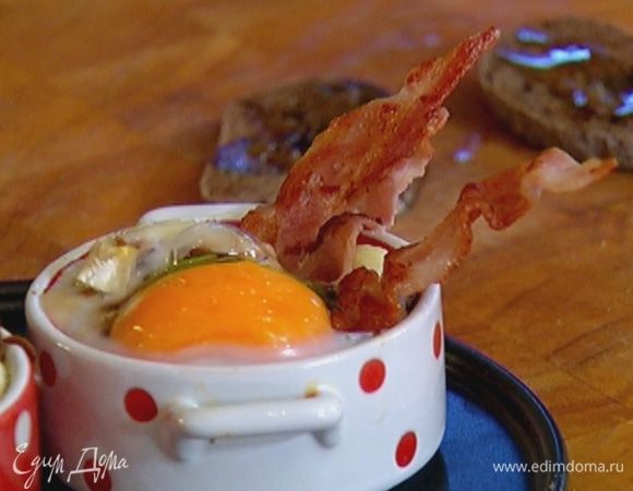 Обжаренные полоски бекона разрезать пополам и воткнуть в яичницу, подавать с тостами.