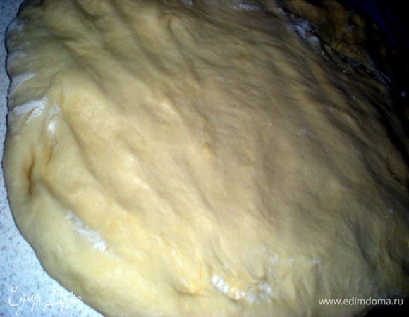 Достаем тесто,немного подпылим стол.Выкладываем и разравниваем руками тесто в прямоугольник.