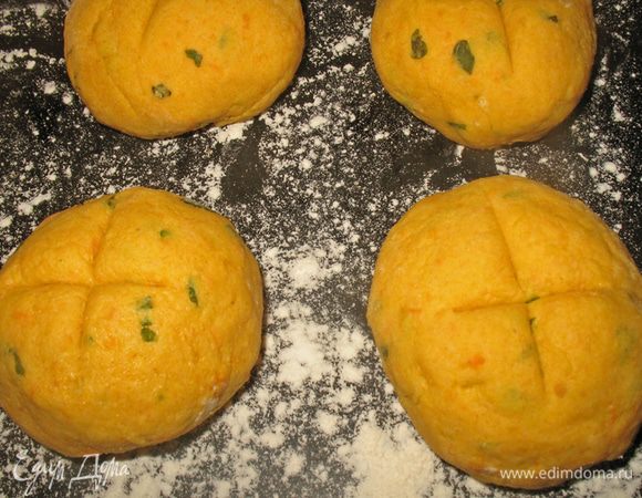Противень посыпать мукой или выстелить пергаментом для выпечки. Выложить шарики на противень и маленьким острым ножом на верхушке сделать крестообразные надрезы