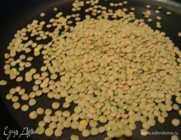 Разогреваем сухую сковороду, высыпаем на нее чечевицу и обжариваем 2-3 минуты на среднем огне, до легкого изменения цвета и появления орехового аромата. Так чечевица лучше сохраняет форму и потом лучше впитывает в себя различные ароматы. После этого отвариваем ее в подсоленой воде, время приготовления обычно указано на упаковке.

