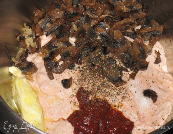 В мой измельчитель по объему больше ничего не влезает, поэтому я соединяю полученный фарш с грибами, сливочным маслом, томатной пастой, солью, перцем и просто перемешиваю миксером. Можно также просто в фарш добавить томатную пасту, сливочное масло, соль и перец и вновь перемешать в измельчителе, а потом уже, добавив грибы, перемешать в миксере. Основная идея: получить однородный фарш с вкраплениями не измельченных грибов.