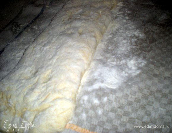 Уложить тесто на полотенце швом вниз.Обильно посыпать мукой сверху.