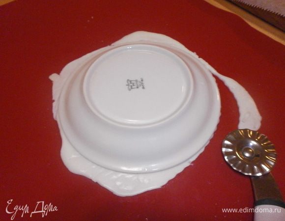 Снять бумагу и вырезать круг. Я использовала блюдце как трафарет. Сложить сырные лепёшки одна на одну, переклалывая пекарской бумагой.