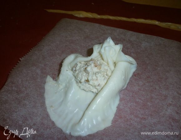 Из разогретых таким же образом пластинок сыра (можно использовать обрезки моцареллы) вытянуть нити.
На каждый круг сыра положить начинку - крем и собрать в мешочек. Закрепить нитями из сыра.