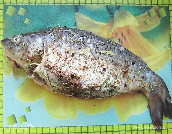 Плотно заложить начинку в брюшко карпа.