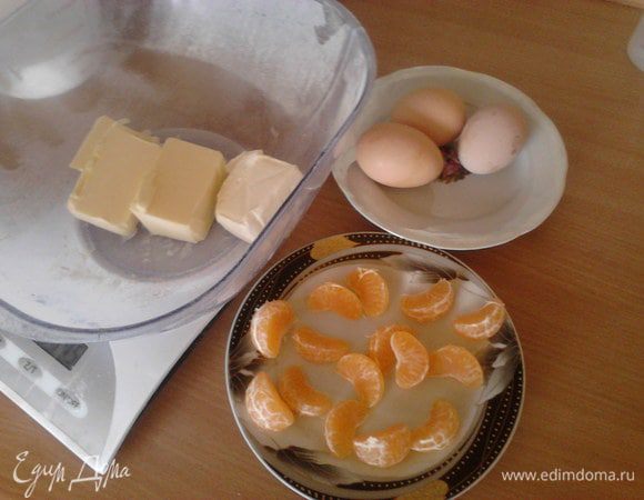 Очистить мандарины и оставить их на 1 час подсыхать, масло и яйца вынуть из холодильника, что б они приобрели комнатную температуру.  Сухофрукты вымыть и замочить в коньяке.
На сковороде обжарить мандарины в 20 г слив. масла с 1 ст. л. сахара. Выложить дольки на тарелку, вместо них на сковороде прогреть сухофрукты пока коньяк не выпарится.
Всё остудить.