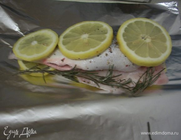 Рыбу выложить на лимон, чтобы не пригорела. Положить рядом веточку розмарина. Завернуть в фольгу и запекать 20 - 25 минут при температуре 180 - 200 градусов.