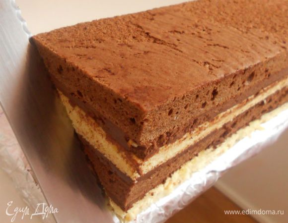 Затем положите пирог длинной стороной параллельно краю стола. Длинным ножом для хлеба разрежьте его диагонально на 2 части, направляя нож от ближнего нижнего угла к дальнему верхнему. Получатся две треугольные части.