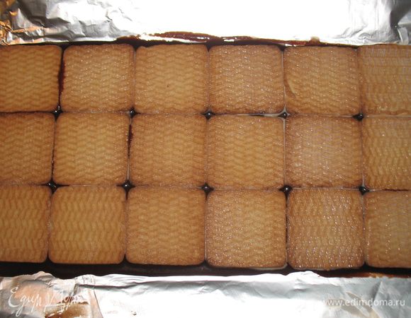 Печенье окунаем в молоко и выкладываем его на глазурь. 