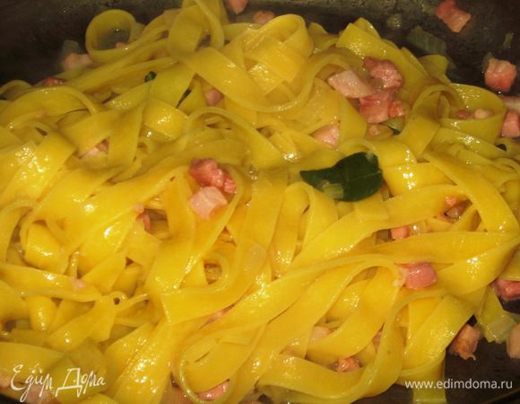 Поместить тальятелле к бекону,влить воду от варки пасты,хорошо перемешать и прогреть нa огне 3-4 минуты.