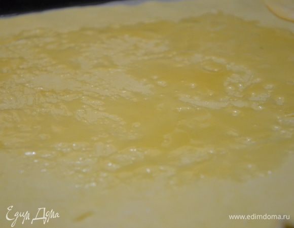 Тонко раскатать в круг, намотать неплотно на скалку и перенести на противень застеленный пергаментом. Смазать жидким медом.