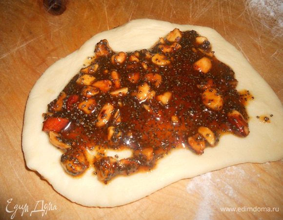 Когда тесто подошло разделить на одинаковые кусочки, размять руками каждый в пласт, смазать начинкой.