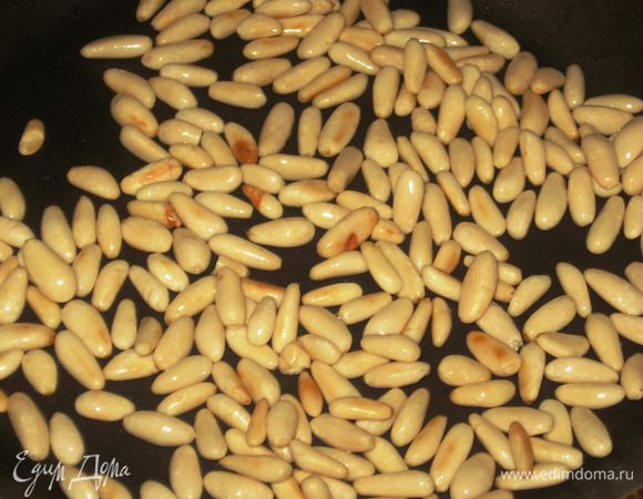 В сковороде с антипригарным покрытием обжарить кедровые орешки.