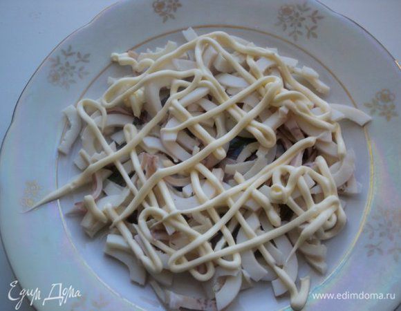 Сборка салата: укладываем слоями ингредиенты, нанося на каждый слой сеточку из майонеза. Первый слой – кальмары.