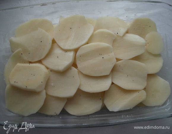 Духовку разогреть до 200 градусов. Ломтики картофеля выложить слоями. Каждый слой посолить и поперчить. 
