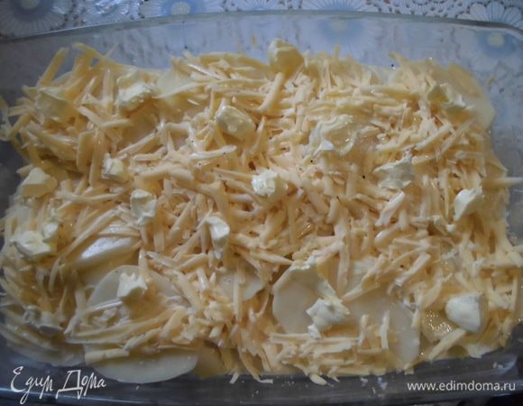 Сливки смешать с молоком, также посолить и поперчить. Сыр натереть на терке и присыпать им картофель. Полить запеканку  сливочно-молочной смесью. Сверху разбросать небольшие кусочки сливочного масла. 