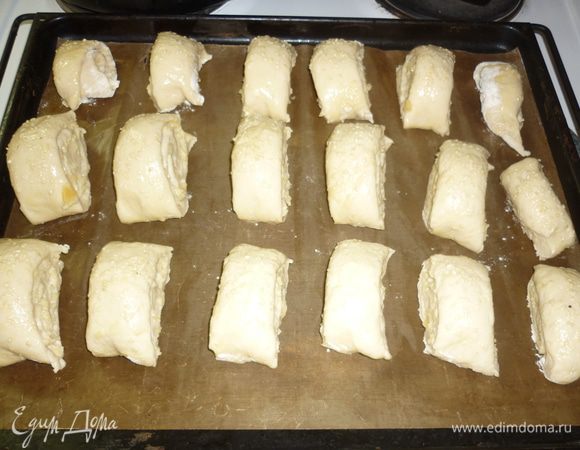 теперь очередь острого ножа. нарезаем рулетик на булочки шириной 2-3 см, укладываем на противень, заботливо укрытый бумагой для выпечки, не требующей (или требующей) смазывания маслом (тут все зависит от цены и производителя). я пользуюсь уже полгода тефлоновой салфеткой. ее не надо смазывать, легко мыть. она только ножа боится. отправляем булочки в печь (тем, кому повезло) или духовку 