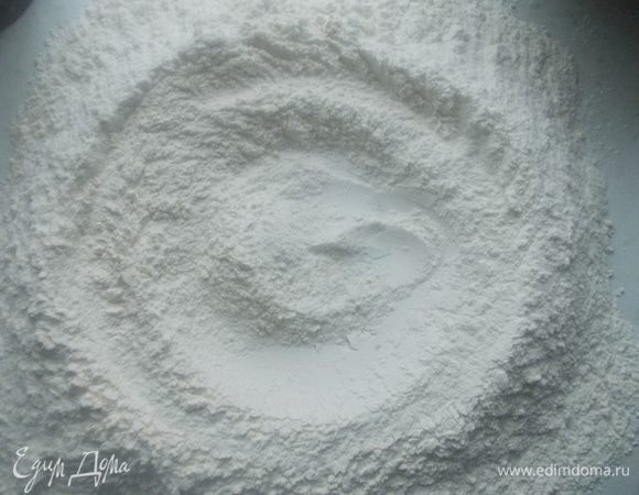 Муку смешать на столе и сделать в середине воронку, добавить соль.