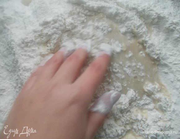 Вылить в муку всю воду и растворенные дрожжи, начать замешивать тесто.