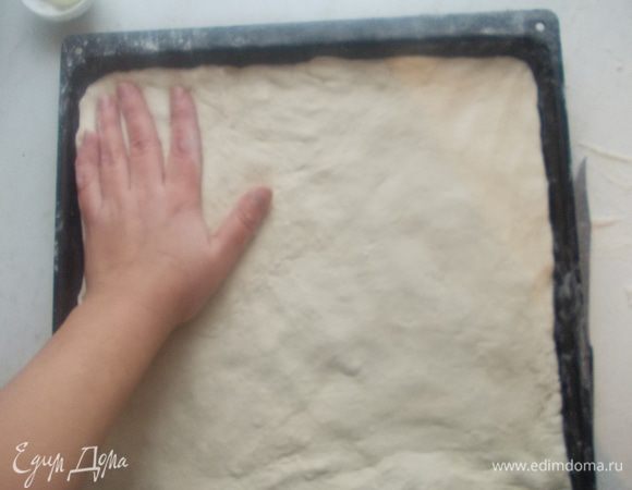 Уложить на противень, что бы была равномерная толщина теста.