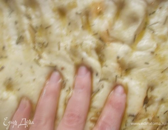 Розмарин, чеснок, соль и оливковое масло растереть в ступке. Полить сверху тесто и пальцами помять его, как бы втирая масло.