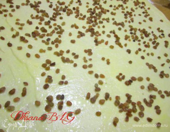 На тесто нанести масло и посыпать изюм