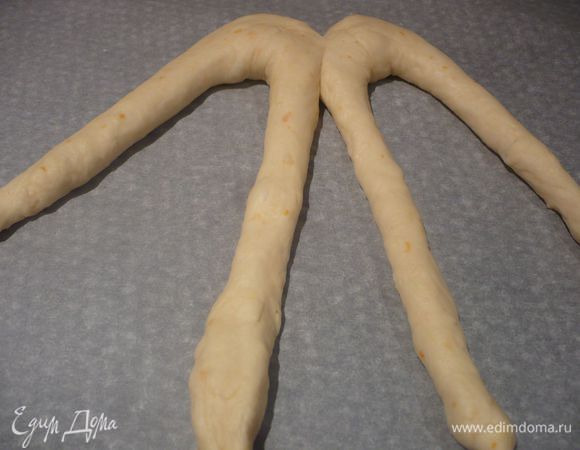 Тесто разделяем на четыре равные части. Каждую часть делим на две части и скатываем в тонкие жгуты длиной примерно 40 см. Жгуты перегибаем посередине и укладываем рядом. Сверху кончики сдавливаем между собой. 