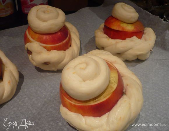 Накрываем яблоки крышечкой и каждый кусочек оставшегося теста скатываем в жгут, сворачиваем его в форме улитки и укладываем на крышку из яблока. 