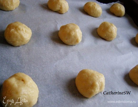 Возьмем одну столовую ложку теста, скатаем шарик. Выложим на противень, застеленный пергаментом. Скатаем 24 шарика. Стараемся, чтобы они были одного размера.