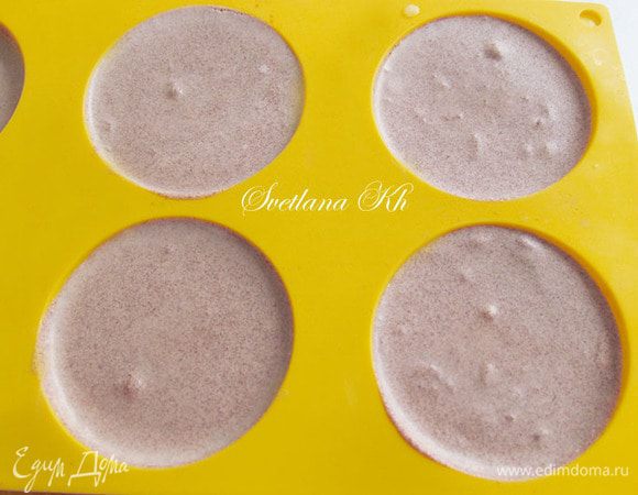 Силиконовые формы заполнить полученным муссом и  немного  охладить .
Диаметр форм должен быть равен диаметру пирожных и вырезанным заготовкам из бисквита.
В центр формочки с муссом опустить изготовленные ранее конфеты с марципаном. Опускать ребром. Поставить для застывания в морозилку на несколько часов.