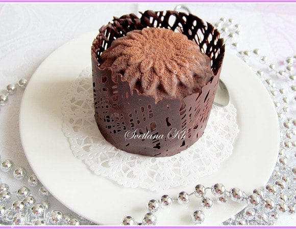 Пирожное обернуть лентой с шоколадом и поставить в холодильник на 10 минут. Затем аккуратно снять бумагу. Поверхность пирожного посыпать какао для бархатной текстуры. Хранить в холодильнике.