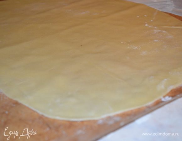 раскатываем первый кусочек в прямоугольник, как можно тоньше! Получается прямоугольник  размером на 3/4 противня! Я его сразу переложила на коврик для выпечки. 