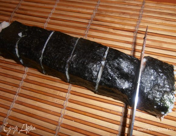 Нарезаем очень острым ножом,прорезая особенно нижний слой водорослей!