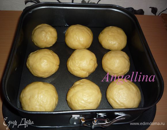 Через полчаса форму для выпечки смазать сливочным маслом. Тесто разделить на 9 частей, сформировать из них небольшие шарики и выложить их в подготовленную форму (форма не должна быть холодной). Между булочками  надо оставить расстояние 1,5-2 см. Накрыть форму полотенцем и поставить в теплое место еще на полчаса для расстойки.