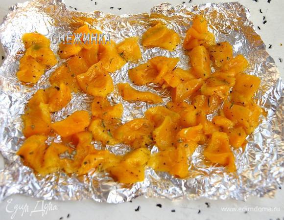 Тыкву нарезаем тонкими полосочками-квадратиками, кладём в миску, сбрызгиваем растительным маслом, посыпаем солью, перцем и сухими травами, перемешиваем. Выкладываем на фольгу и запекаем в течение 10 минут при 190С.