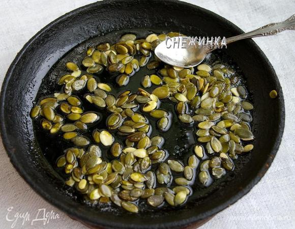 На сухую разогретую сковороду насыпаем сахар, добавляем воду и кипятим несколько секунд. Кладём в сироп тыквенные семечки, перемешиваем.