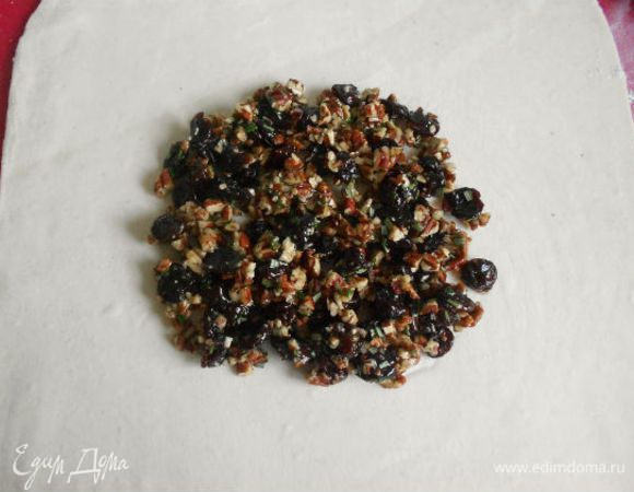 На присыпанной мукой поверхности раскатать тесто в квадрат. Центр должен быть чуть толще, чем края. Полученную смесь выложить на тесто в центре в виде круга  