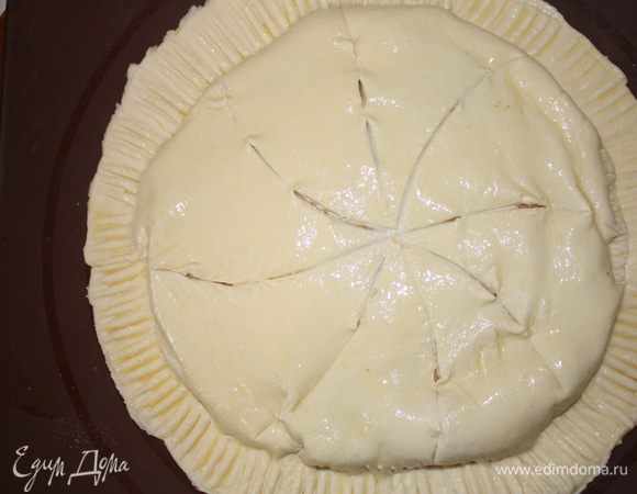 Смазываем яйцом и ножом наносим надрезы,похожие на спицы колеса.Ставим в холодильник на 1 час. Духовку разогреваем до 190 градусов и отправляем его туда на 30-35 минут.