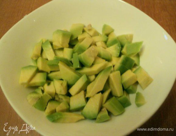 Авокадо разрезать пополам, удалить косточку, очистить от кожицы. Порезать мякоть авокадо кубиками, сложить в миску и полить лимонным соком, что бы  не потемнел.