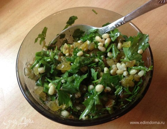 В миске смешать кедровые орехи, соль, перец, изюм, петрушку и оливковое масло. Разогреть духовку до 190 градусов.