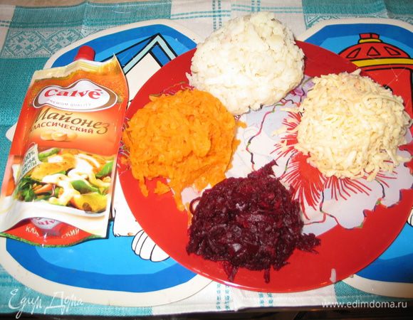 На мелкой тёрке натереть картошку, морковку, белки, желтки и сыр. Рыбу с маслом и размять вилкой.
