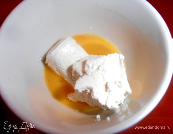 У меня яйцо крупное, поэтому делим его на две чашки (если мелкие яйца, то просто возьмите два)... В одну чашку добавим творог с сахаром.