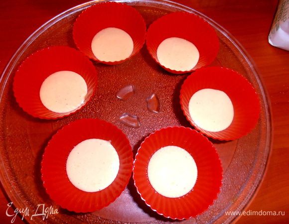 Распределяем половину теста по формочкам(по 1 ст. л.).Лучше сразу поставить их на стеклянное блюдо из микроволновки!