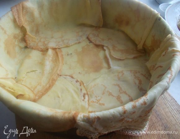 Затем по краю выкладываем блины, чтобы они свисали с формы.