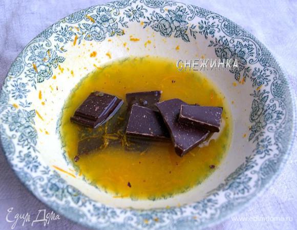 Готовим глазурь. В миску или кастрюльку натираем цедру апельсина, затем выдавливаем сок, кладём поломанный на кусочки шоколад и ставим на водяную баню. Доводим до растворения шоколада, перемешиваем до однородности. 