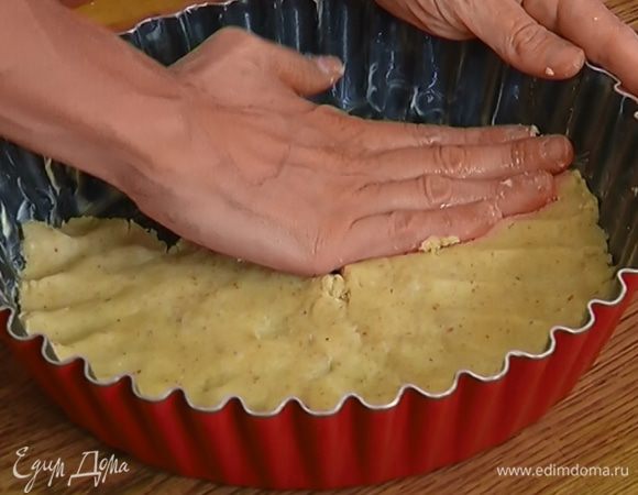 Глубокую форму смазать оставшимся сливочным маслом, выложить на дно тесто слоем в 1/2 см и отправить в морозильник на 30 минут.